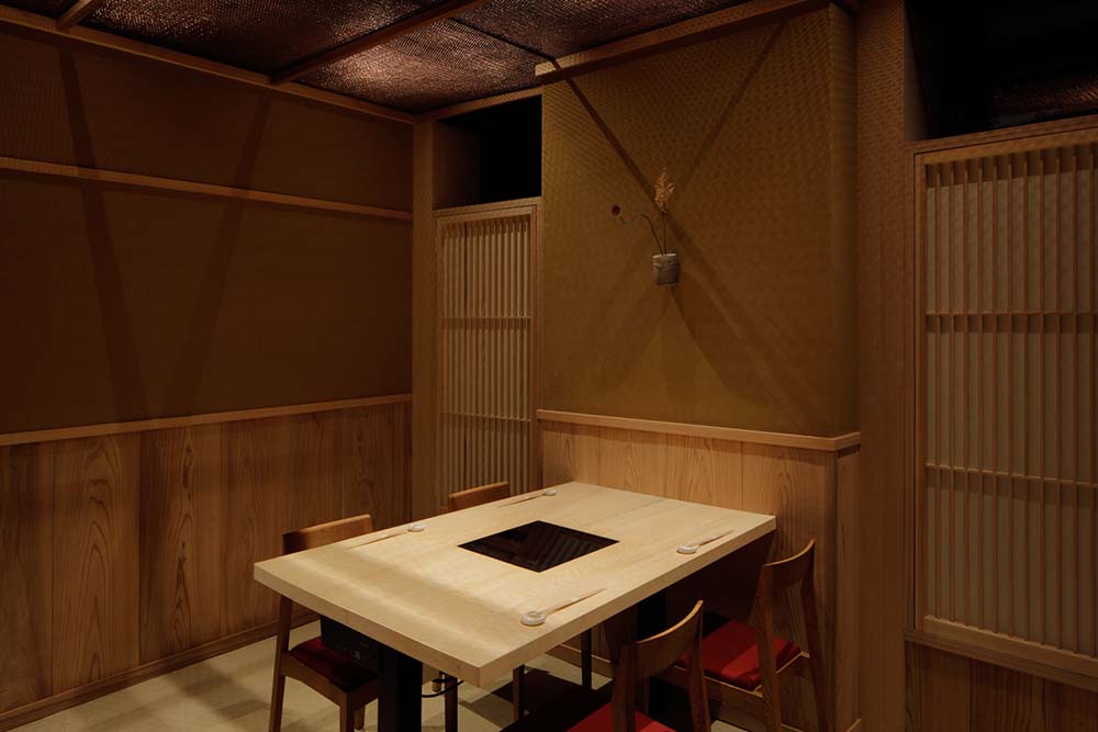 这个用餐区有一张靠墙放置的木制矩形餐桌，搭配现代的红色椅子。