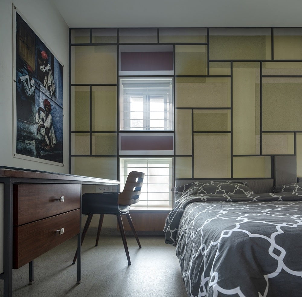 这是一个近距离观察的卧室有图案的床单在床上补充的几何图案的墙在床头板的后面。