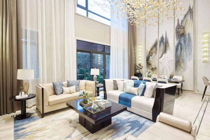 这是一个好莱坞华丽风格的客厅，现代元素，明亮的沙发和深色的咖啡桌下的大型装饰灯。