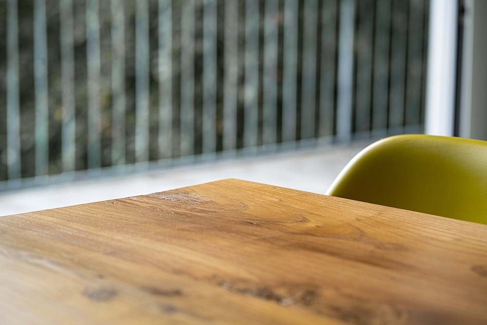 这是一个近距离观察木餐桌和它的纹理与现代椅子搭配。