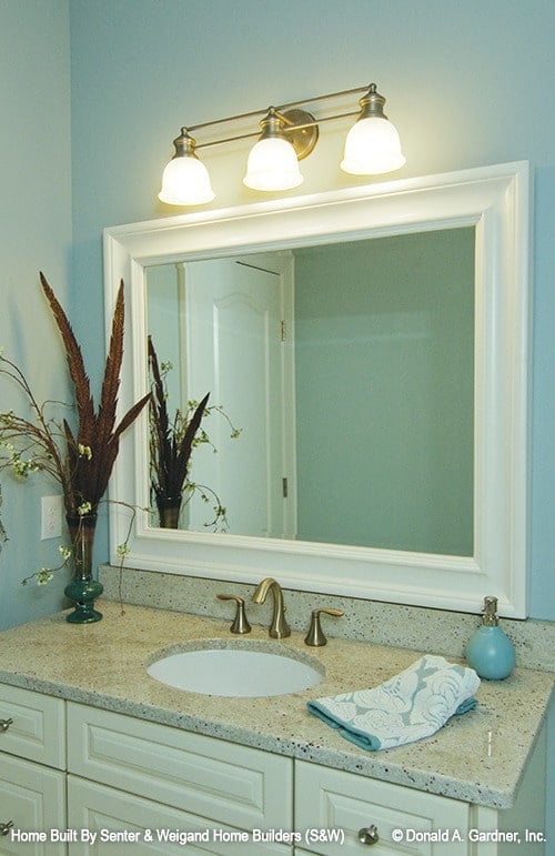 浴室带有洗手台，配以白色框窗和玻璃壁灯。