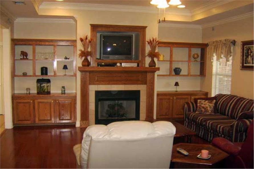 客厅有条纹沙发，白色皮革躺椅，木桌，壁炉顶部有电视。客厅有条纹沙发，白色皮革躺椅，木桌，壁炉顶部有电视。