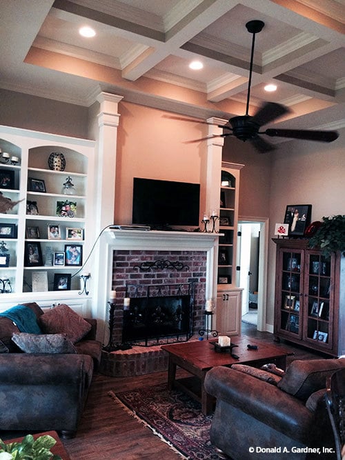 一座砖砌壁炉、白色嵌壁式壁炉和悬挂在格子天花板上的一把铁扇使客厅更加完整。