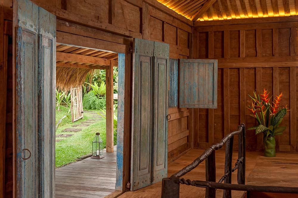 这是房子内部的木质双扇门，有木墙和硬木地板。