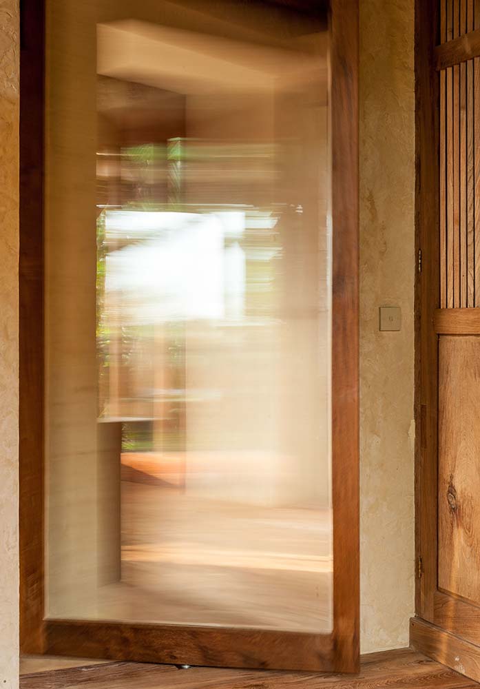 这是一个近距离观察房子的玻璃门，它有木制框架，与周围的木制元素和结构相匹配。