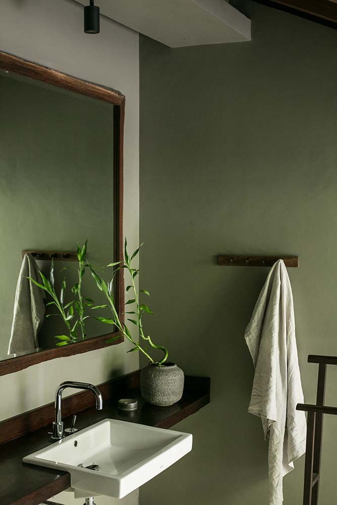 这是另一间浴室，有一个简单的木制洗手台和梳妆台，上面有一面大镜子。