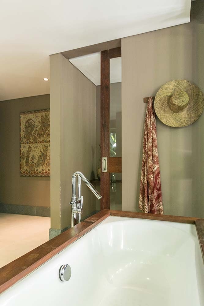 这是一个白瓷水槽，上面有一面大镜子，旁边有挂毛巾和帽子的钩子。