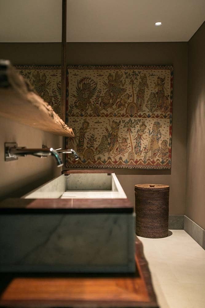 这是对浴室的近距离观察，并辅以远处墙上挂着的彩色图案挂毯。