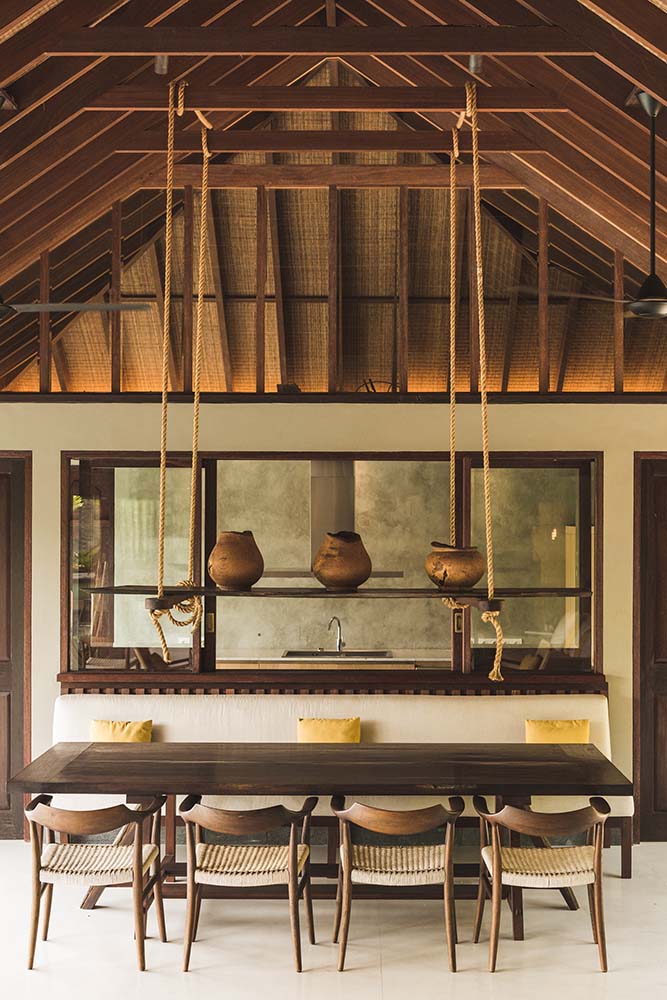 这是房子的餐厅，有一个巨大的长方形餐桌，周围是木椅，顶部是乡村元素。