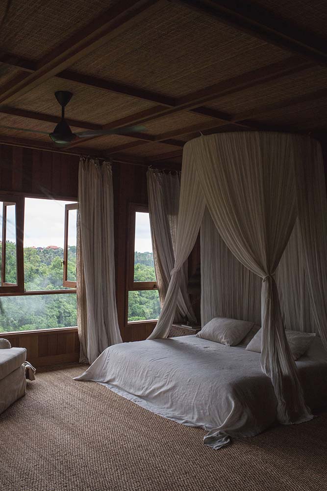 这是一个近距离观察的卧室大床,窗帘挂在天花板微笑。然后以自然灯光作为补充。