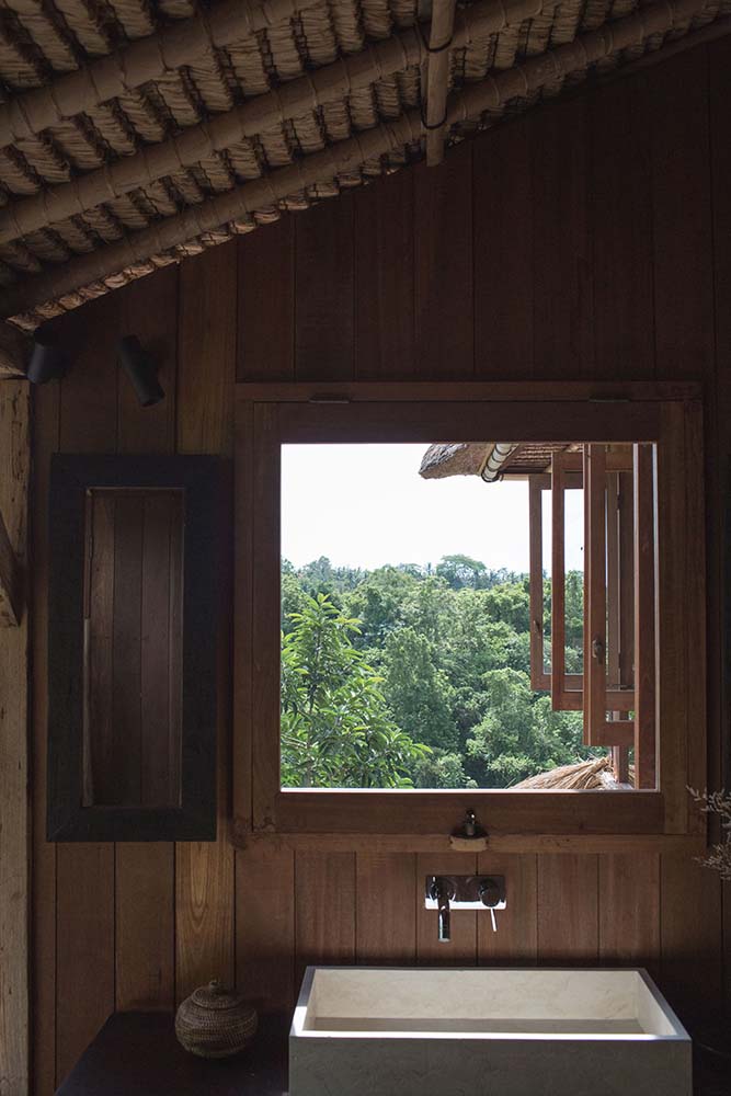 这个房子的角落里有一个水槽顶部设有一个大型木制窗户,让室内木制墙壁在黑暗的自然采光。