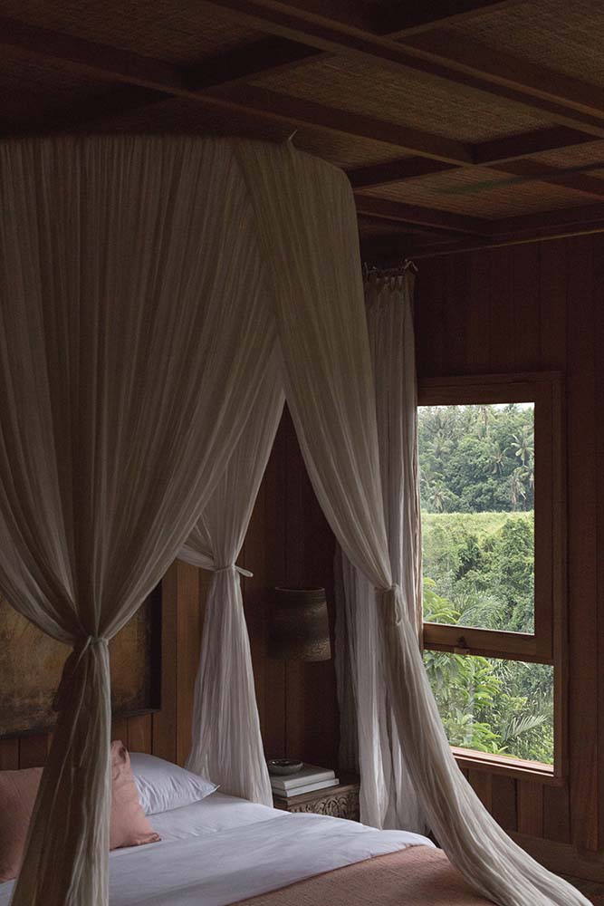 这是仔细看看床上环绕着木制的天花板上悬挂的窗帘。