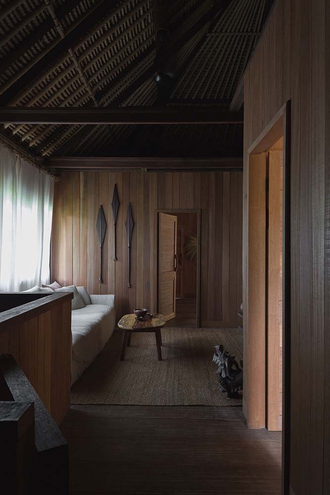 这个卧室有高大的木制墙壁的一边的沙发上,是一个内置的木质结构搭配了一个木制的咖啡桌。