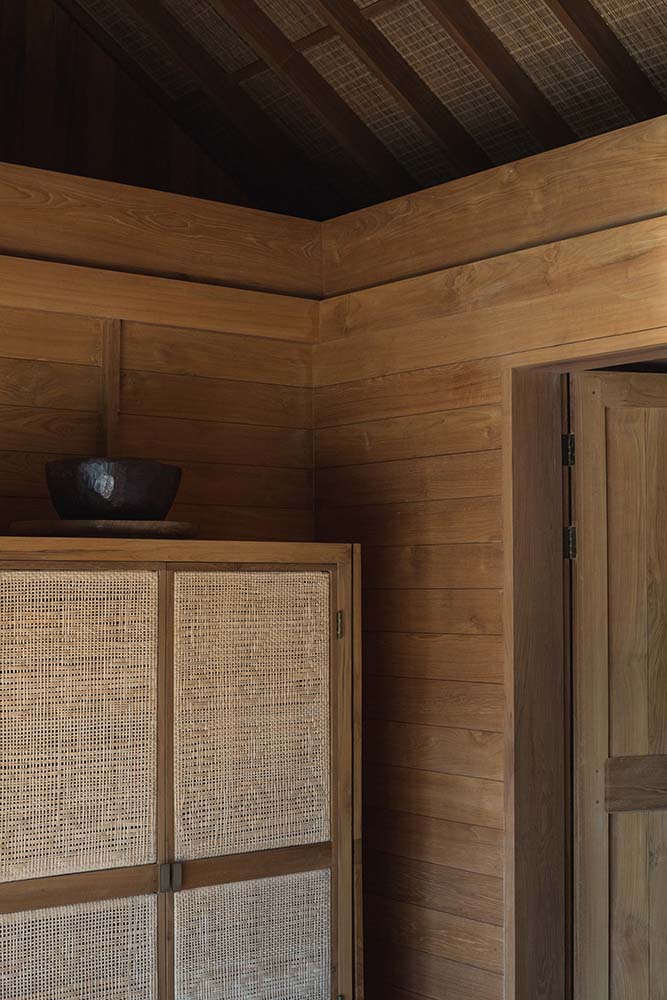 床的一侧是大木柜和梳妆台，柜门上有质朴的编织元素。