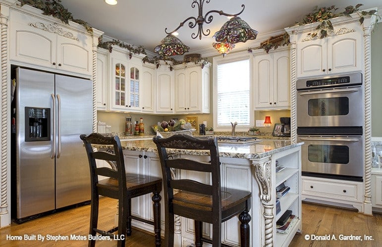 厨房提供白色橱柜，不锈钢电器，花岗岩台面，和早餐岛。
