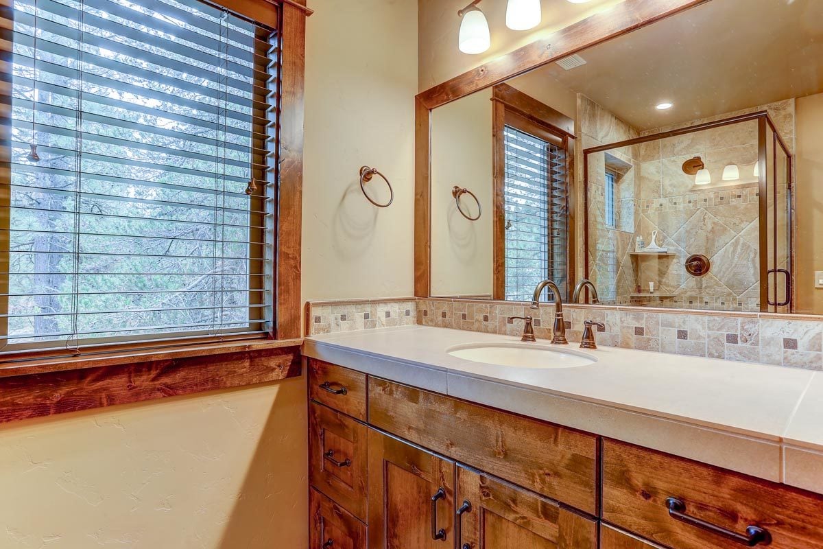 仔细看看洗手台梳妆台，有木制橱柜、石英台面和一面大矩形镜子。