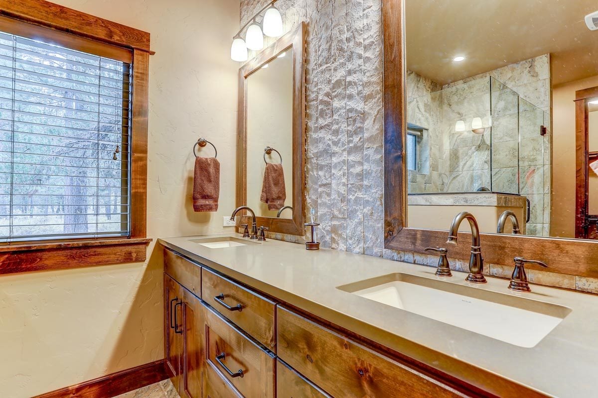 另一间浴室带木制梳妆台，配有双水槽和镜框镜子。