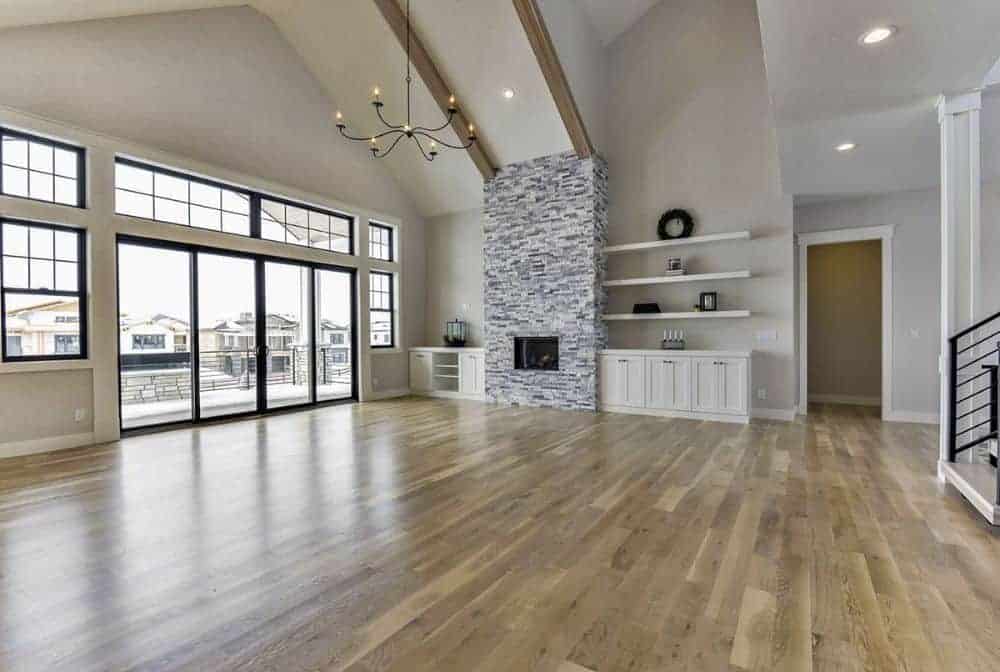 客厅里有一座砖砌壁炉、白色嵌壁式壁炉和一个拱形天花板，天花板上有外露的木梁。