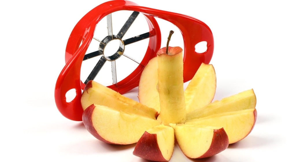 仔细看一个苹果切片机和一个切片的苹果。