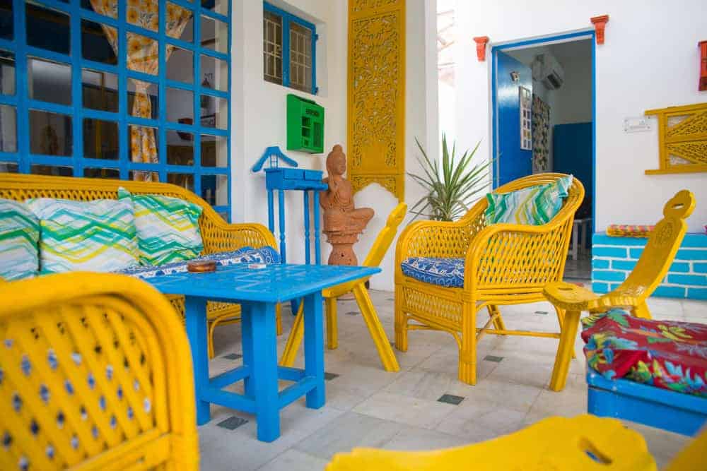 近距离观察一个波西米亚风格的露台，有色彩丰富的家具，与墙上的艺术品和窗框相匹配。