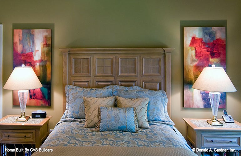另一间卧室里有一张雕花木床，两侧有配套的床头柜和艺术品。