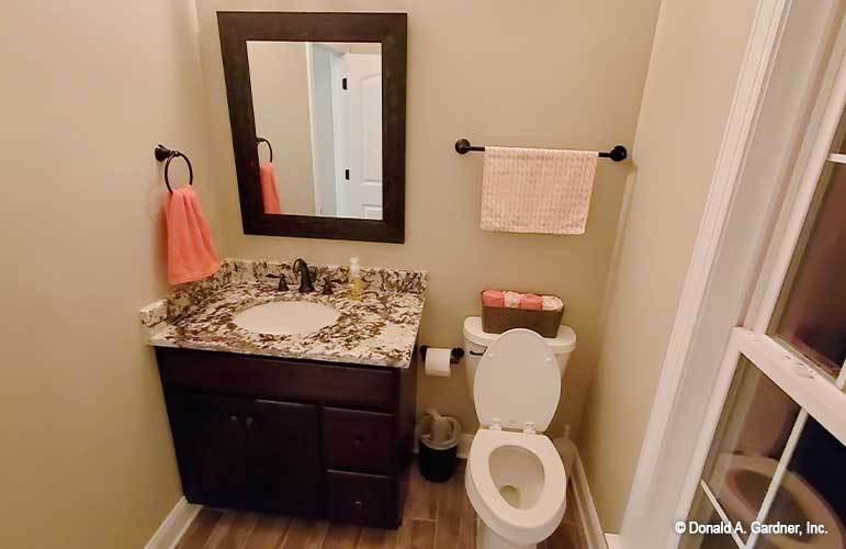 盥洗室里有一个洗手台，硬木地板上有一个厕所。