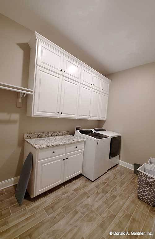 洗衣房，白色电器，花岗岩台面，白色橱柜。