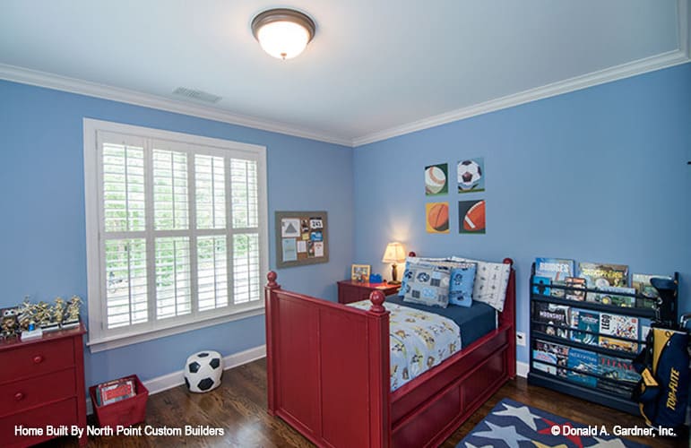 儿童卧室，蓝色墙壁，红木家具，深色硬木地板。