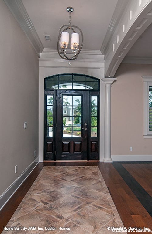 门厅配有球形吊灯和硬木地板，装饰着中央大理石瓷砖。