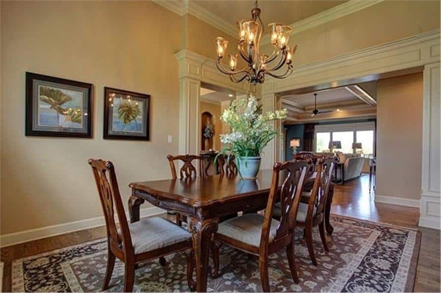 客厅提供米色的部分，柳条躺椅，和一个镀铬控制台桌面与镜面墙壁艺术。
