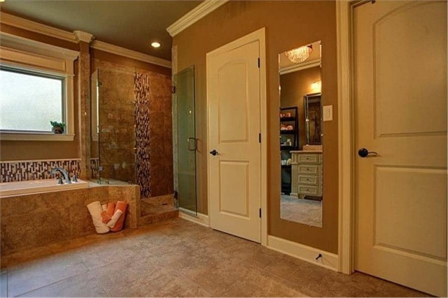 主浴室包括一个步入式淋浴间、一个卫生间和一个隐藏在白色门后的步入式衣橱。