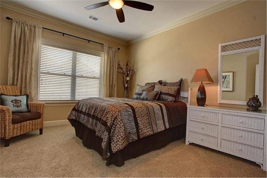 卧室的墙壁是米黄色的，地板是地毯，窗框上挂着灰色的窗帘。