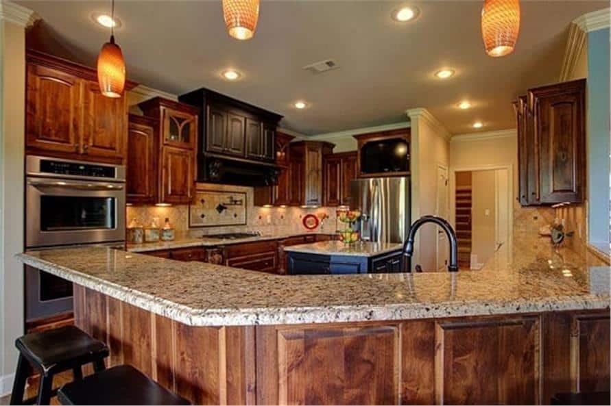 厨房配有天然木橱柜，不锈钢电器，花岗岩台面和凸起的用餐吧台。