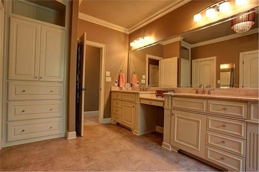 主浴室有一个高橱柜和一个双洗手台梳妆台，配有一面无框镜子。