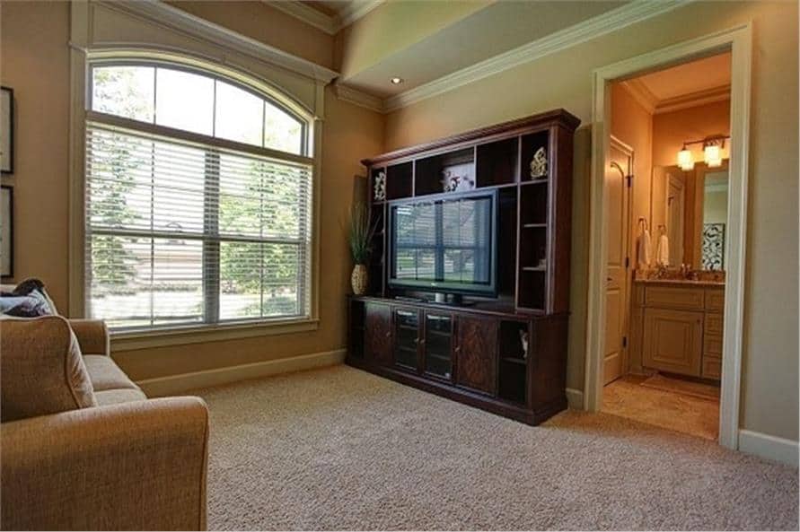 家庭娱乐室，米色沙发，电视放在深色木柜子上。