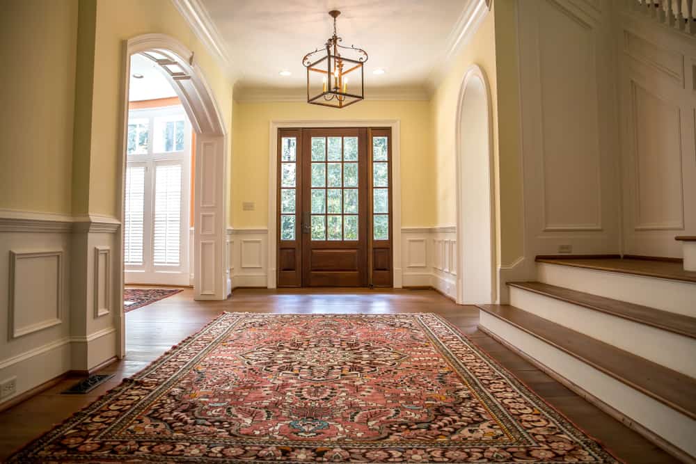 这是一个简单的门厅，有硬木地板，上面有彩色图案的东方地毯。