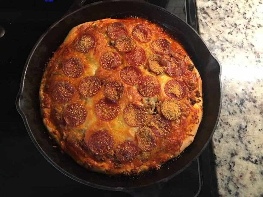 新鲜出炉的铁锅深盘披萨配意大利辣香肠。