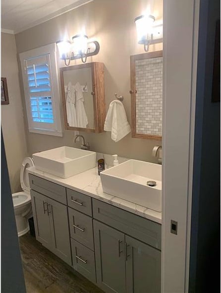 主浴室设有一间厕所和一个带双容器水槽和镜像药柜的大理石梳妆台。