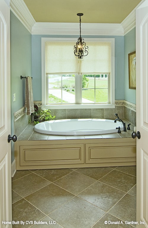 主浴室包括一个落水式浴缸，由一个华丽的吊坠和白色框窗的自然光照亮。