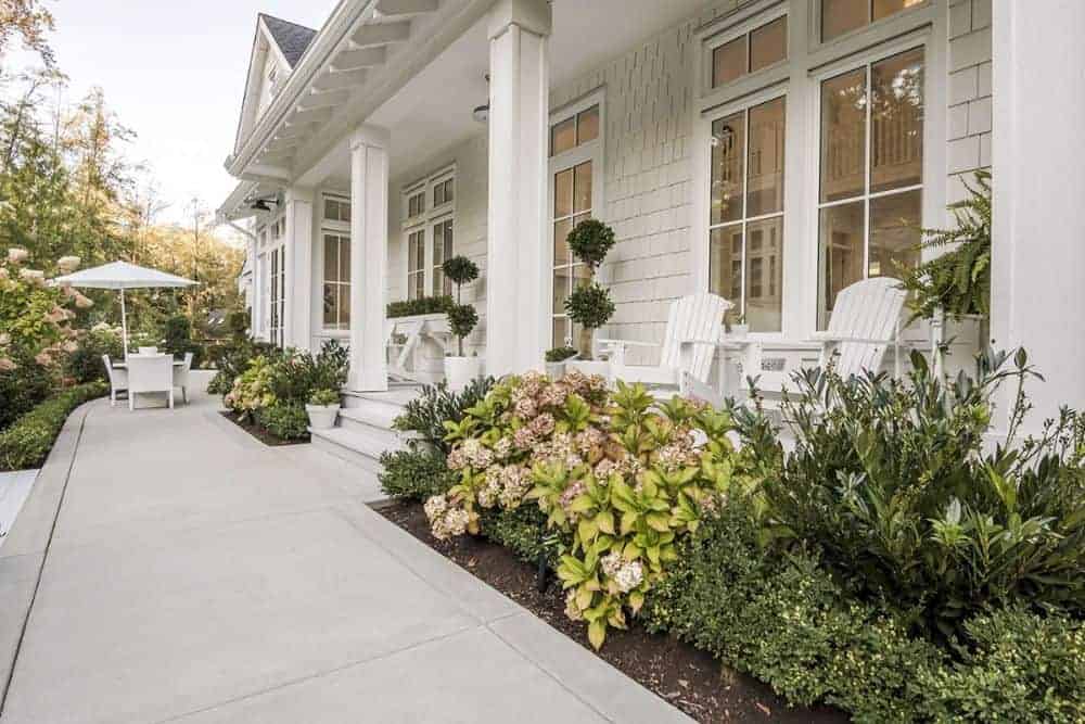 覆盖玄关装饰柱,白色的摇椅,和新鲜的盆栽植物。