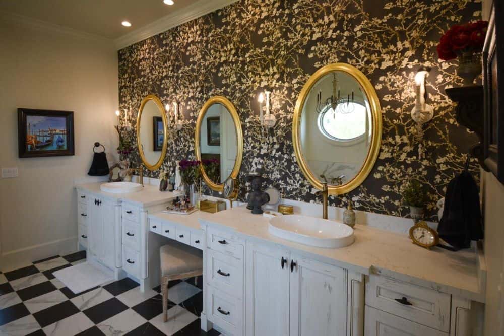 主浴室提供双虚荣和化妆品柜台搭配圆形镜子。