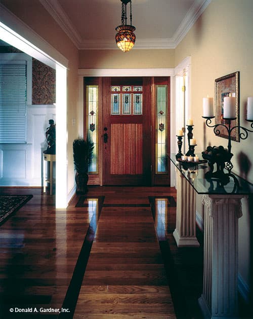 门厅里有一扇木质前门，还有一张玻璃顶的控制台桌子，上面放着装饰蜡烛。