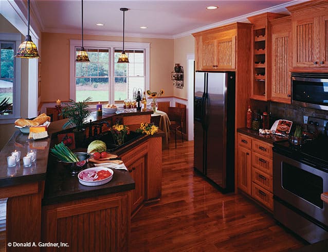 厨房配备了木制橱柜、石板电器和一个带凸起用餐吧台的弧形岛。