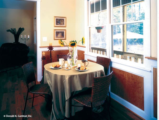 早餐角提供了一个圆形的四人餐厅，放置在白色框窗的旁边。