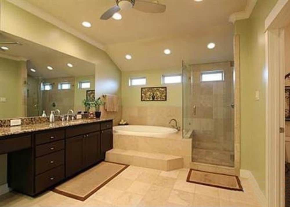 主浴室带步入式淋浴，一个深泡浴缸，和一个双水槽梳妆台，上面有一面宽无框镜。