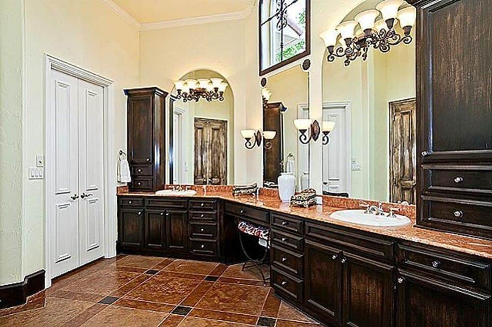 主浴室设有一个双洗手池梳妆台，顶部设有无框镜子和木橱柜。