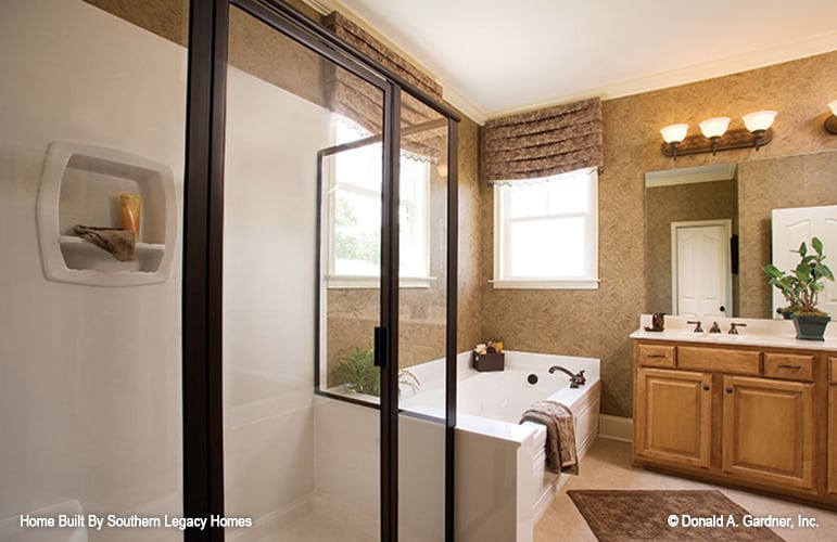 主浴室有一个步入式淋浴间，一个插入式浴缸，和一个双水槽梳妆台搭配一个大无框镜子。