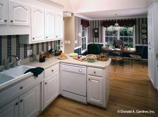 厨房配有白色电器，定制橱柜，双碗水槽搭配鹅颈水龙头。