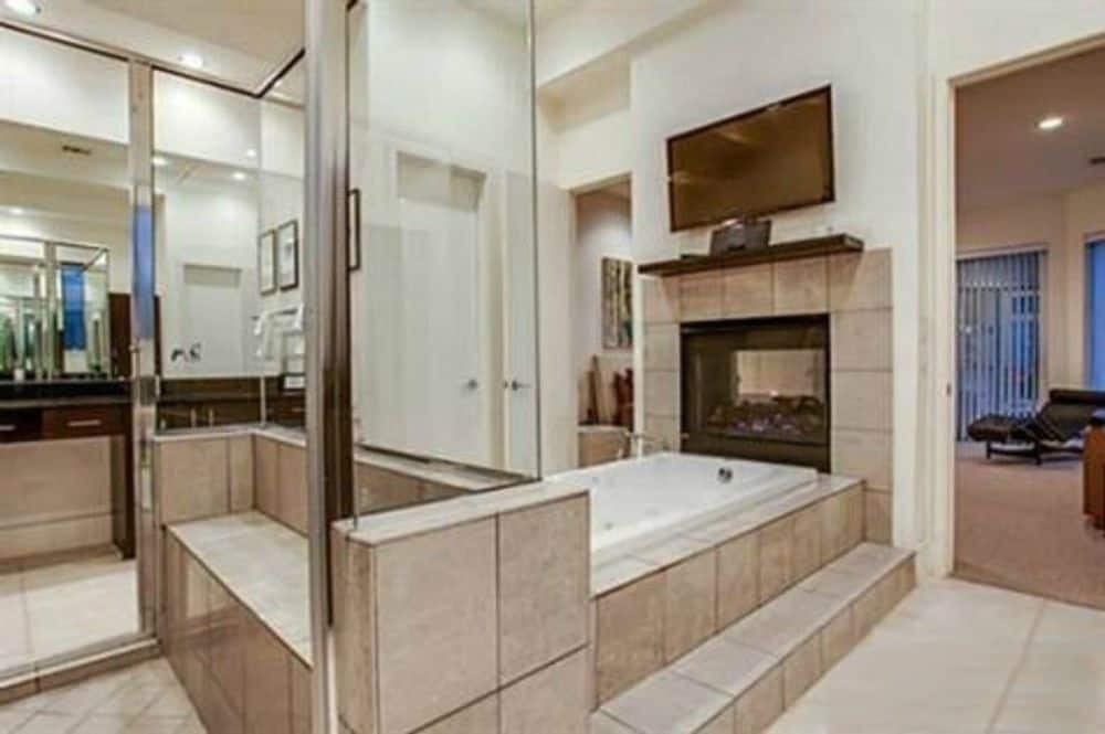 主浴室设有一个深浸浴缸，顶部设有一座双面壁炉和一台壁挂式电视。