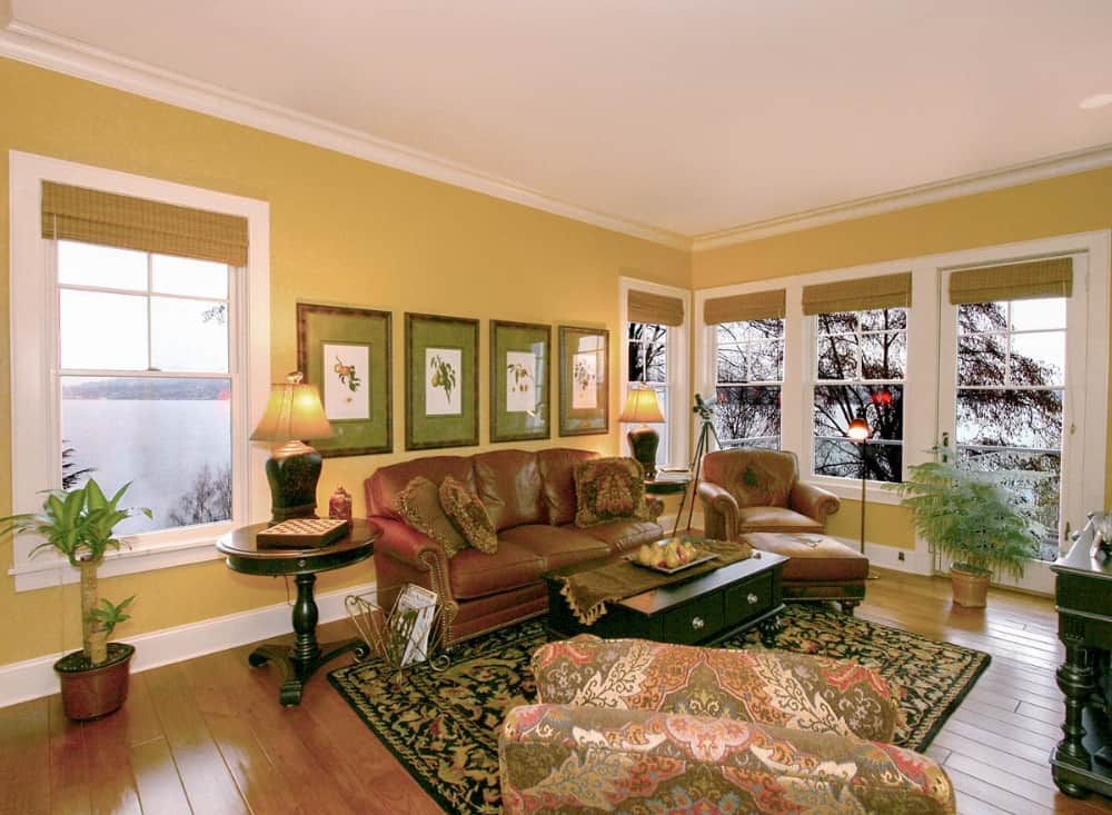 家庭娱乐室有舒适的座椅，黑色图案的地毯，宽木板地板上的黑色桌子。